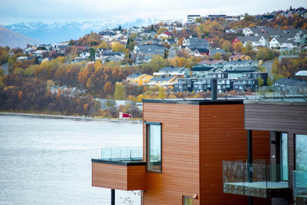 Moderne trekledde leilighetsbygg på en skråning over fjorden, brukt som illustrasjon i artikkel om seksjoneringsbegjæring.